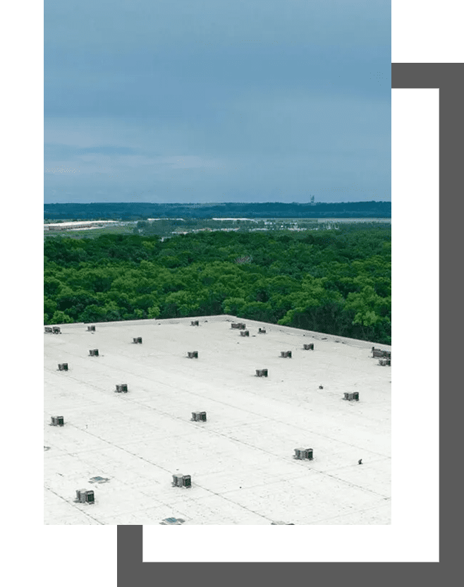 A large white roof with trees in the background.